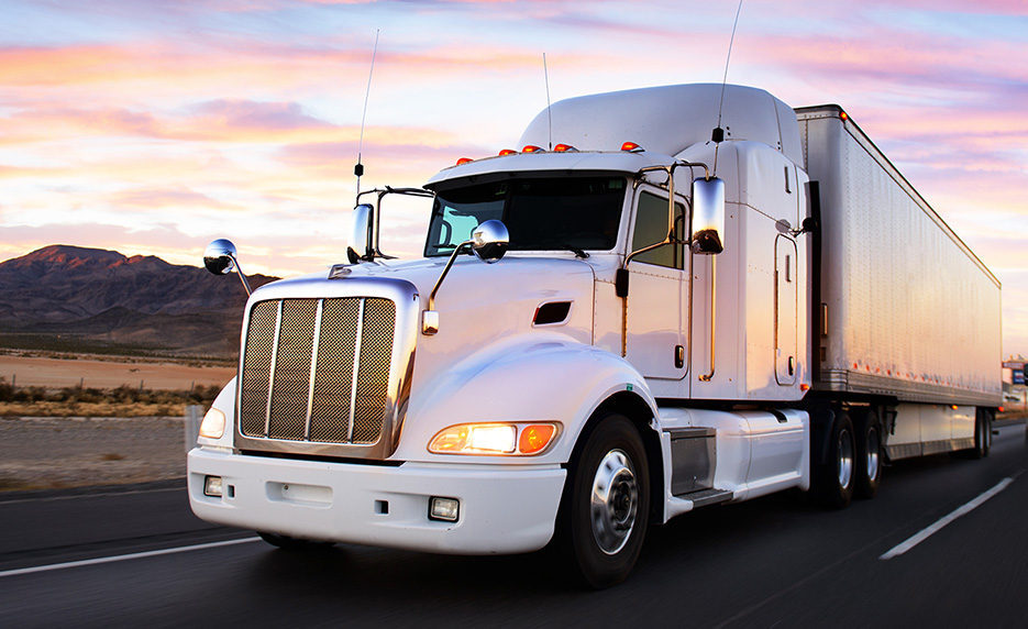 tractor trailer truck on highway at sunrise